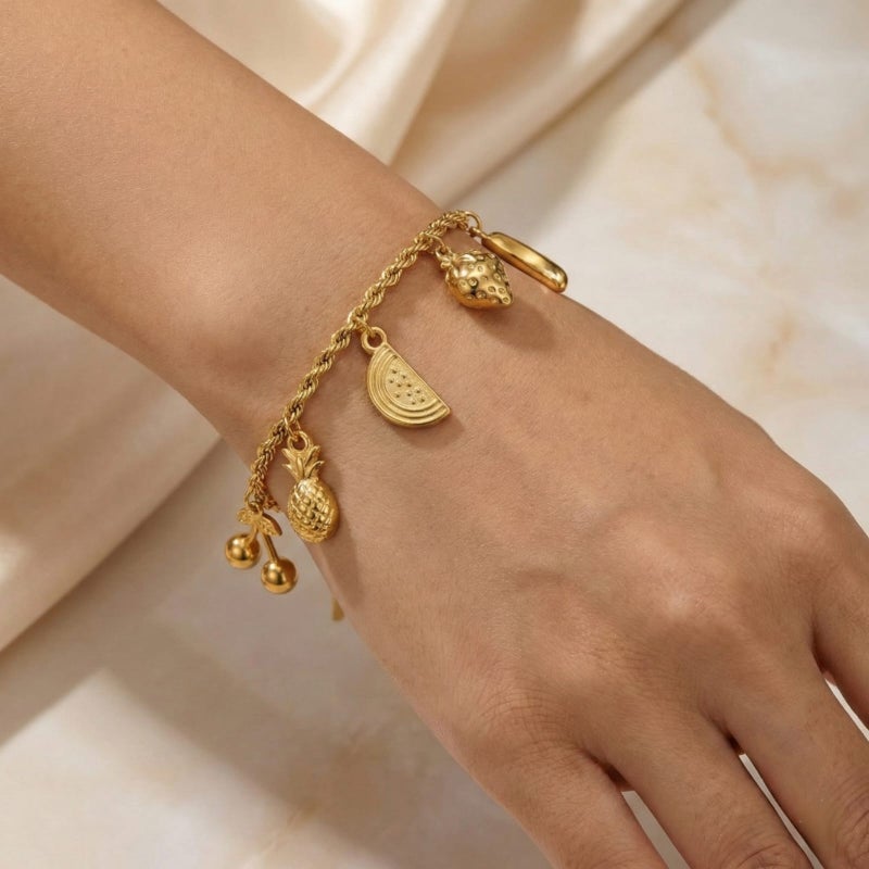 انسيال ذهبي أنيق مصنوع من الستانلس ستيل المقاوم للصدأ، يتميز بسلسلة مجدولة جذابة تزينها دلايات أشكال فواكه مبهجة، مع قفل قابل للتعديل ليناسبكِ. - Image 3